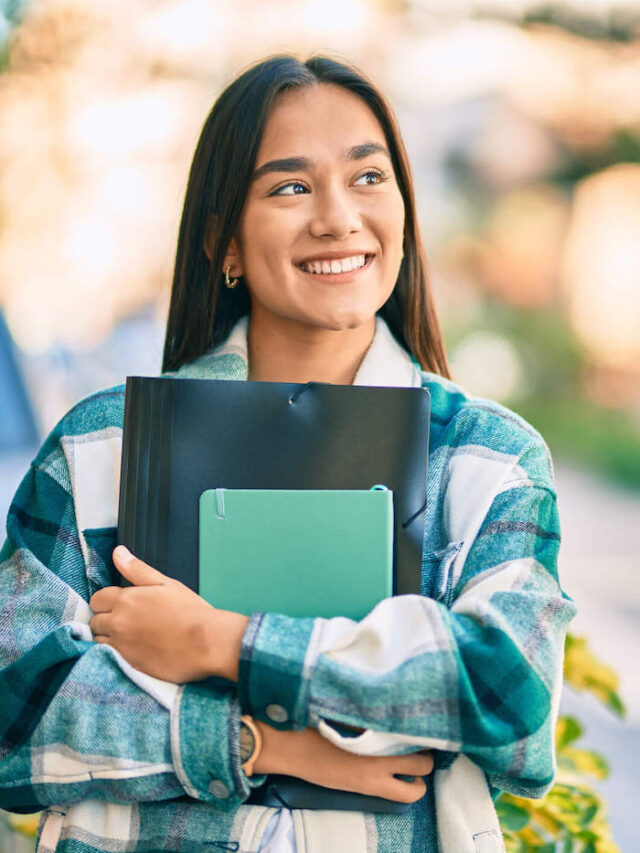 cropped-College-Student-Smiling-Outside-As-She-Holds-Her-School-Folder-1.jpg