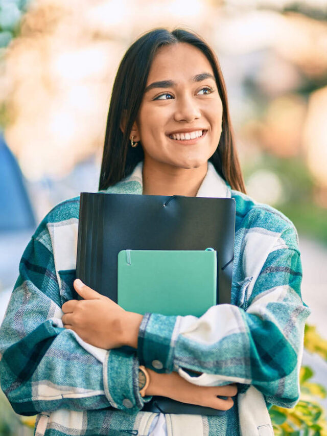 cropped-College-Student-Smiling-Outside-As-She-Holds-Her-School-Folder.jpg